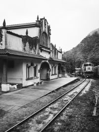 Railroad tracks amidst buildings against clear sky