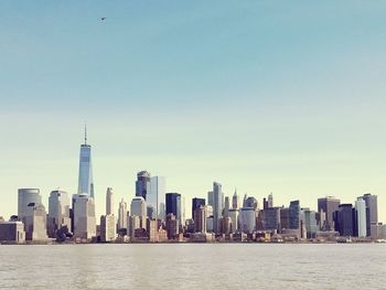 Sea and cityscape against clear sky