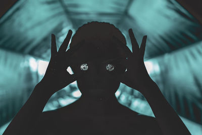 Close-up of silhouette woman holding diamond