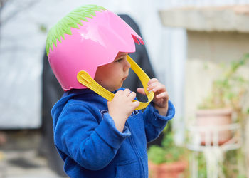 Cute toddler boy pretending to be a football player with an easter basket for a helmet