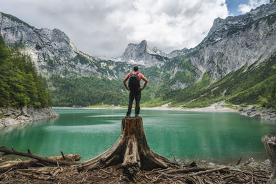 Rear view of woman standing by lake