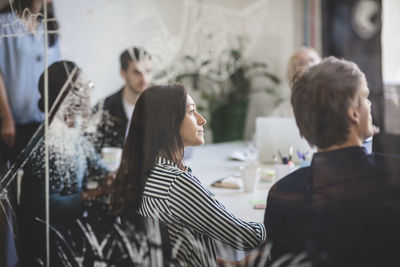 Creative business people listening while sitting in conference room