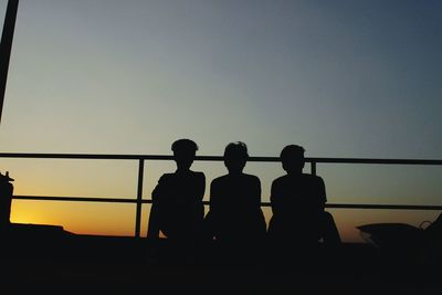 Silhouette people against clear sky during sunset