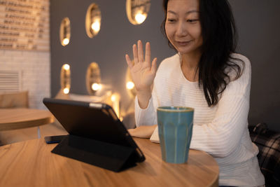 Young woman using mobile phone on table