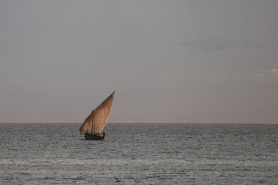 Sailboat on sea against sky during sunset