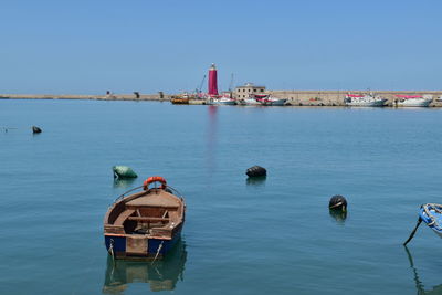 Ship in sea against clear blue sky