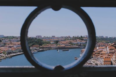 View of townscape against sky seen through metal