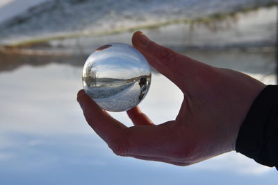 Close-up of hand holding crystal ball