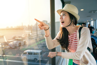 Young woman wearing hat standing outdoors