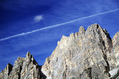 Low angle view of rocks against blue sky