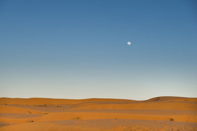 Scenic view of desert against clear blue sky