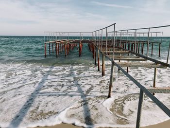 Wooden pier on sea against sky