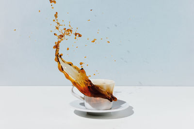 Close-up of coffee cup on table against white background