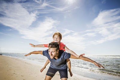 Full length of young woman at beach against sky