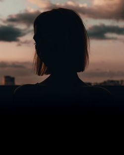 Rear view portrait of silhouette woman standing against sky during sunset