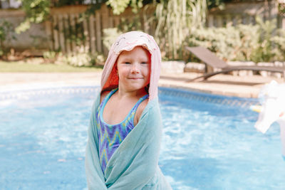 Portrait of smiling girl standing in swimming pool