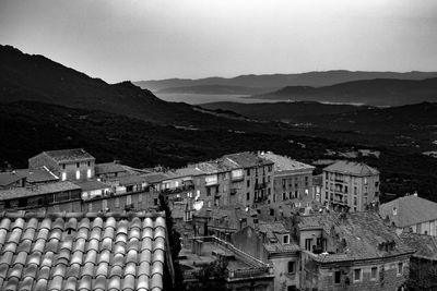 High angle view of townscape by mountains against sky