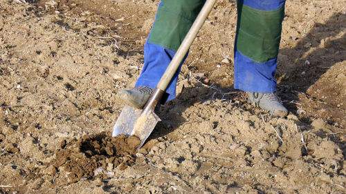 Low section of man digging in mud