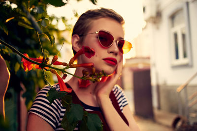 Portrait of woman holding sunglasses