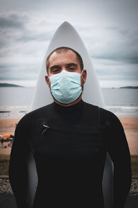 Portrait of man standing at beach against sky