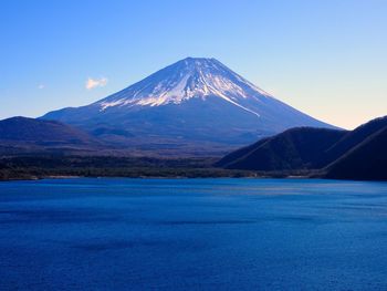 Scenic view of snowcapped mountain against blue sky