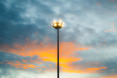 Low angle view of illuminated street light against sky at sunset