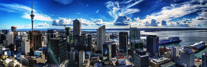 Aerial view of cityscape against cloudy sky