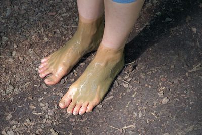 Low section of woman standing on wet land