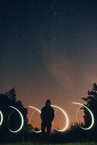 Silhouette man on field against sky at night