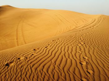 Sand dunes in desert against sky