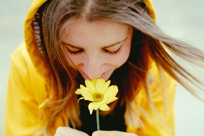 Woman smelling yellow daisy