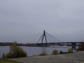 Bridge over river against sky in city