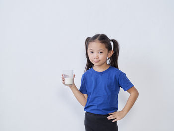 Portrait of a boy drinking water against white background
