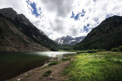 Scenic view of river amidst mountains against sky