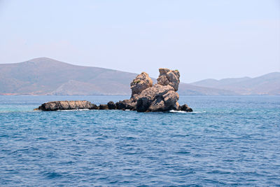 Scenic view of rocks in sea against clear sky