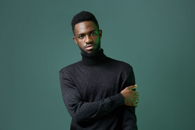 Young man standing against blue background