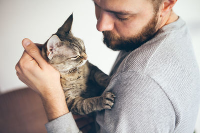 Close-up of man with cat at home