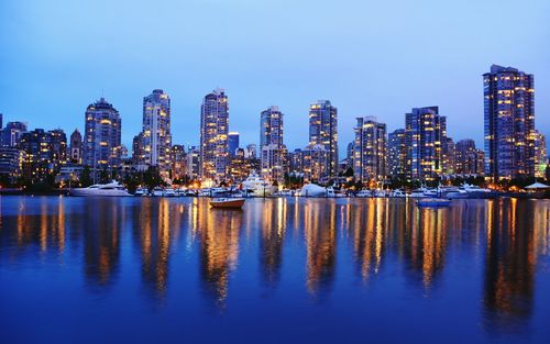 Reflection of buildings in city at waterfront