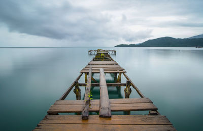 Pier over lake against sky