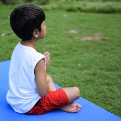 Asian smart kid doing yoga pose in the society park outdoor, children's yoga pose. the little boy