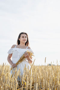 Young woman standing against sky