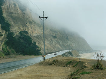 Road by rain storm mountain cloud against sky 