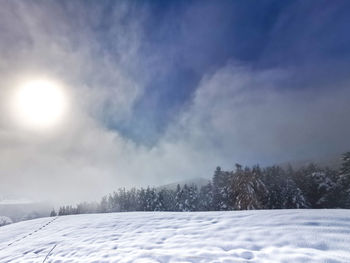 Snow covered landscape against sky