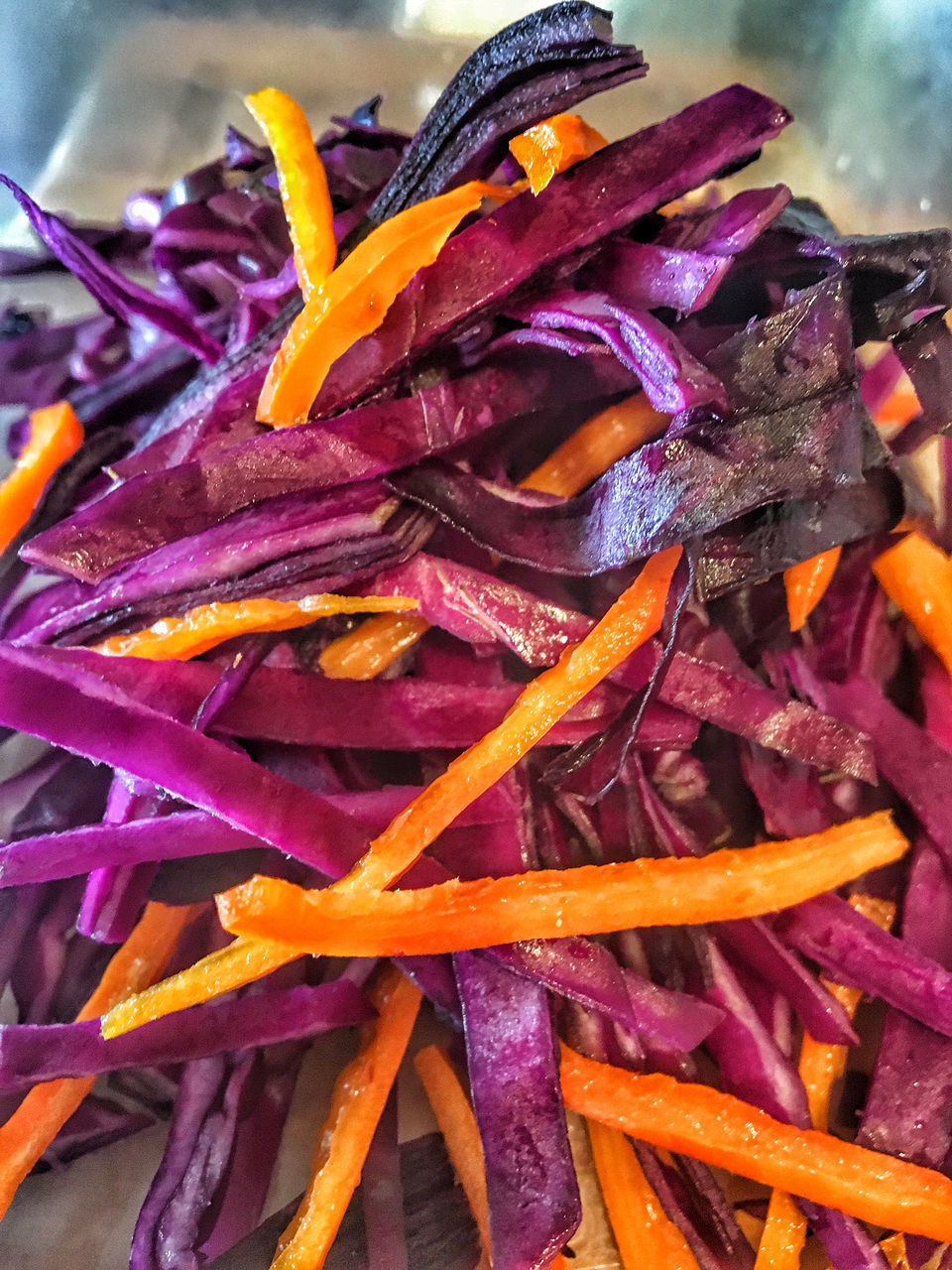 DETAIL SHOT OF PURPLE CHILI PEPPERS ON RED ROSE