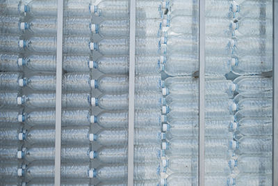 Full frame shot of plastic bottles in racks at factory