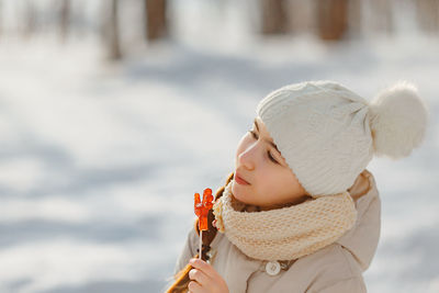 Close-up of teenage girl holding candy outdoors during winter