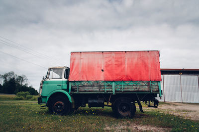 Low angle view of vehicle on field against sky