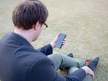 Rear view of man using mobile phone
