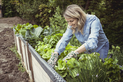 Woman standing by plants in farm