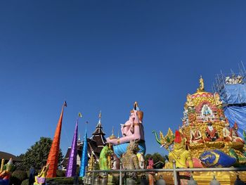 Low angle view of temple against building against clear blue sky